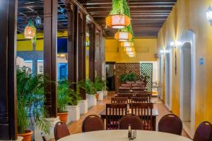 a restaurant with tables and chairs and potted plants at Hotel Antigua Comayagua in Comayagua
