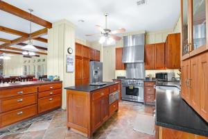 a large kitchen with wooden cabinets and stainless steel appliances at River Nest in Wimberley