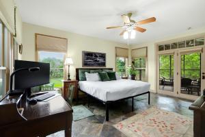 a bedroom with a bed and a desk with a computer at River Nest in Wimberley