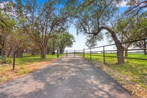a road with a fence and trees and grass at River Nest in Wimberley
