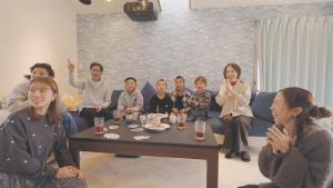 a group of people sitting in a living room at まるで映画館 本格シアター 寝室6部屋 大家族大集合 海まで徒歩すぐ ---オーシャニア一宮--- in Ichinomiya
