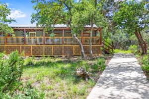 a house with a fence and a walkway at Creekside Vista Escape - Cabin in Wimberley