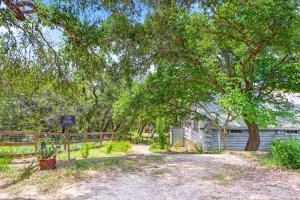 a house with a sign in front of a tree at Creekside Vista Escape - Cabin in Wimberley
