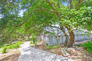 a house with a tree next to a sidewalk at Creekside Vista Escape - Cabin in Wimberley +30 photos
