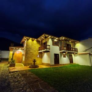 a house with lights on the side of it at night at Hotel Boutique Villa Amonita in Villa de Leyva