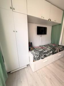 a bedroom with a bed and a tv and cabinets at Le Studio Morny in Deauville