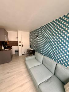 a living room with a couch and a kitchen at Le Studio Morny in Deauville