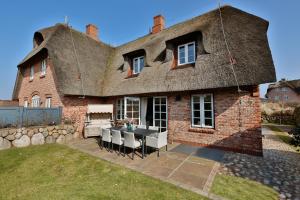 a large brick house with a table in the yard at Sand Beach in Rantum