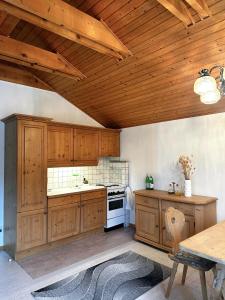 a kitchen with wooden cabinets and a wooden ceiling at Apartment nahe Semmering mit Sauna, Kamin & Terrasse in Enzenreith