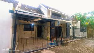 a house with a gate in front of it at Homestay Karimun in Grogol