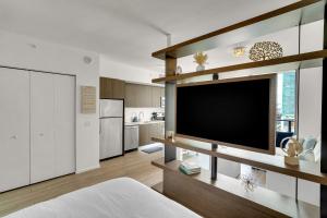 a living room with a large flat screen tv at Azure Miami - Studio Apartment with Stunning City & Bay Views! in Miami