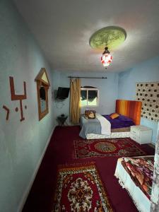 a small bedroom with a bed and a rug at Gite taymate in Zaouia Ben Smine
