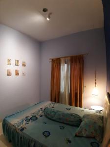 a bedroom with a bed with a green comforter at Orange Villa in Berastagi