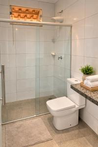 a bathroom with a toilet and a glass shower at Rekanto Canastra in Delfinópolis