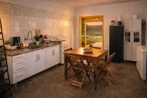 a kitchen with a wooden table and a refrigerator at Rekanto Canastra in Delfinópolis