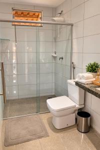 a bathroom with a toilet and a glass shower at Rekanto Canastra in Delfinópolis