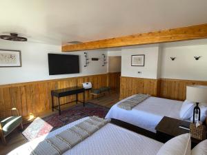 a bedroom with two beds and a flat screen tv at Lava Mountain Lodge in Dubois