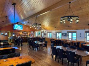 a restaurant with wooden ceilings and tables and chairs at Lava Mountain Lodge in Dubois