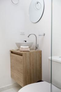 a bathroom with a sink on a wooden stand at Apto cerca Hacienda Nápoles Santorini Río claro Aire acondicionado in Doradal