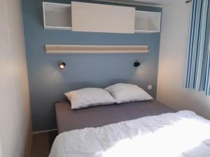 a bedroom with a bed and a blue wall at Breebos Chalet near Antwerp Camp in Rijkevorsel +32 photos