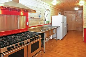 a kitchen with a stove and a refrigerator at Wimberley Log Cabins Resort and Suites- Reunion Cabin in Wimberley