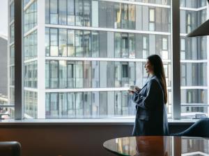 a woman standing in front of a window looking at a book at Sofitel Luxembourg Europe in Luxembourg