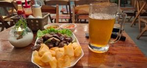 a table with a plate of food and a glass of beer at Bueno Palace Hotel in Macapá