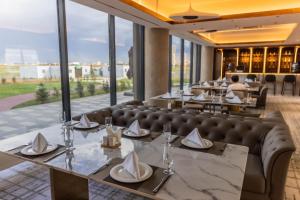 a restaurant with tables and chairs and windows at Green gobi hotel in Dalandzadgad +32 photos