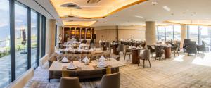 a restaurant with tables and chairs and windows at Green gobi hotel in Dalandzadgad
