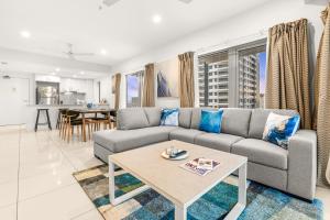 a living room with a couch and a table at Reef-side Splendour City Vistas - Pool - Workspace in Darwin