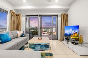 a living room with a couch and a large window at Reef-side Splendour City Vistas - Pool - Workspace in Darwin
