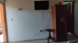 a room with a tv and a cabinet and a stool at HOSPEDAJE EIMy in Purmamarca