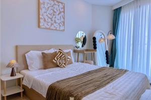 a bedroom with a large bed with blue curtains at The Song Luxury Near Beach Apartment - Căn hộ Nghỉ Dưỡng Cao Cấp Cạnh Biển - Moonlight Homestay in Vung Tau