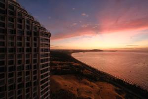 a view of a building and the ocean at sunset at Mandala Cham Bay Mui Ne in Ấp Thiẹn Ái