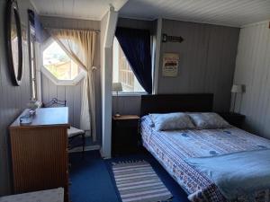a small bedroom with a bed and a window at Habitación Bosque Mar in Isla Negra