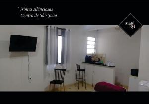 a living room with two chairs and a television at Malý Byt in São João Nepomuceno