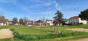 a park with trees and flowers in the grass at A L'OMBRE DES 2 TILLEULS maison d'hôtes adults only in Sainte-Pazanne