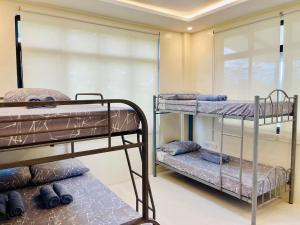 two bunk beds in a room with a window at Camp J Staycation in Cayucay