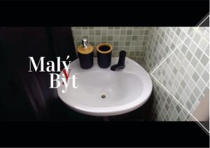 a bathroom sink with two cups on top of it at Malý Byt in São João Nepomuceno