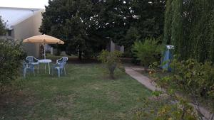 a yard with a table and chairs and an umbrella at Casa Verde 3 in Carhué