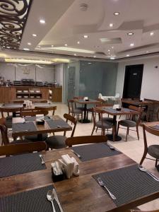 a dining room with tables and chairs and a classroom at TAJ Hotel in Aqaba
