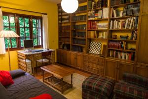 ein Wohnzimmer mit einem Schreibtisch und einem Bücherregal in der Unterkunft Casa da Curuxeira in Santiago de Compostela