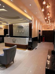 a lobby with a reception desk and a chair at TAJ Hotel in Aqaba