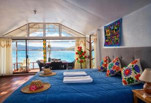 a bedroom with a blue bed with a view of the ocean at uros royal logde in Puno