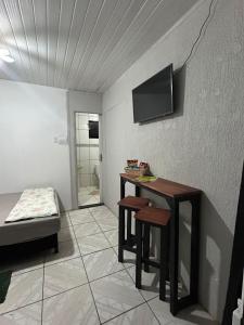 a room with a table and a bed and a television at Vila do Chaves Sr Barriga 70 in Itajaí
