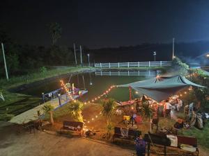a group of people sitting under a tent at night at Min Land Resort in Ban Lan Nok +108 photos