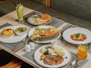 a table with plates of food and drinks on it at Jasmine Grande Residence Suite Bangkok in Bangkok +129 photos