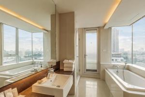 a bathroom with a tub and a sink and a tub and a bath tub at Jasmine Grande Residence Suite Bangkok in Bangkok