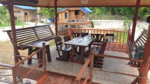 a picnic table and chairs on a deck with a house at Min Land Resort in Ban Lan Nok