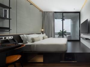 a bedroom with a bed and a desk with a computer at SEENERGY STAY Riverside in Phnom Penh